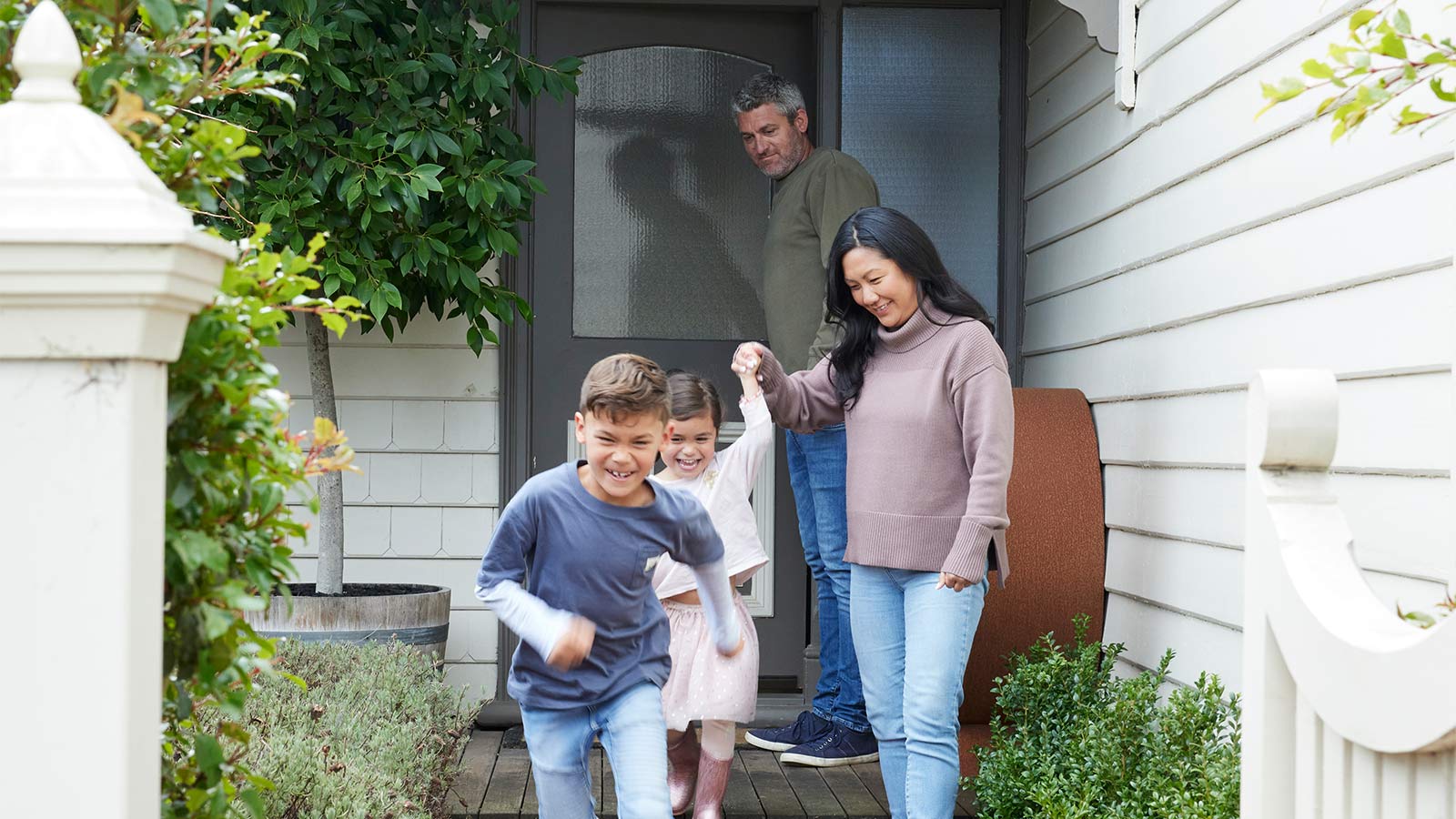 Family leaving their house together, walking off their front porch.