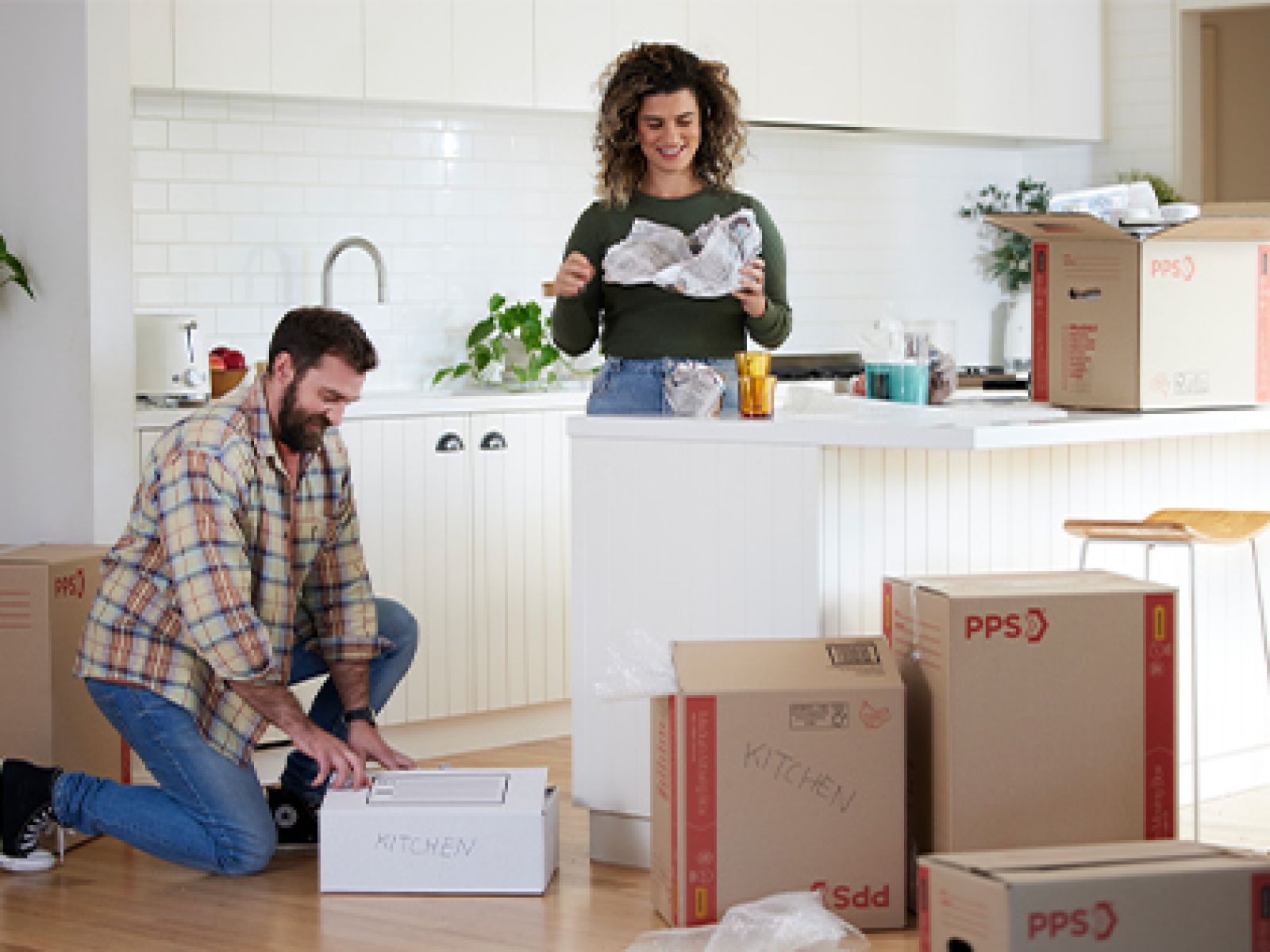 Couple unpacking boxes in their kitchen.