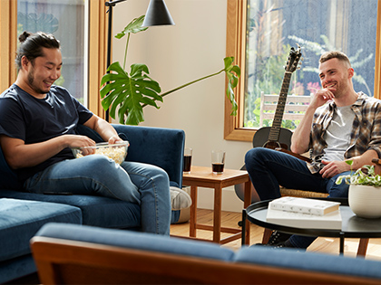 A couple conversing an smiling in their living room.