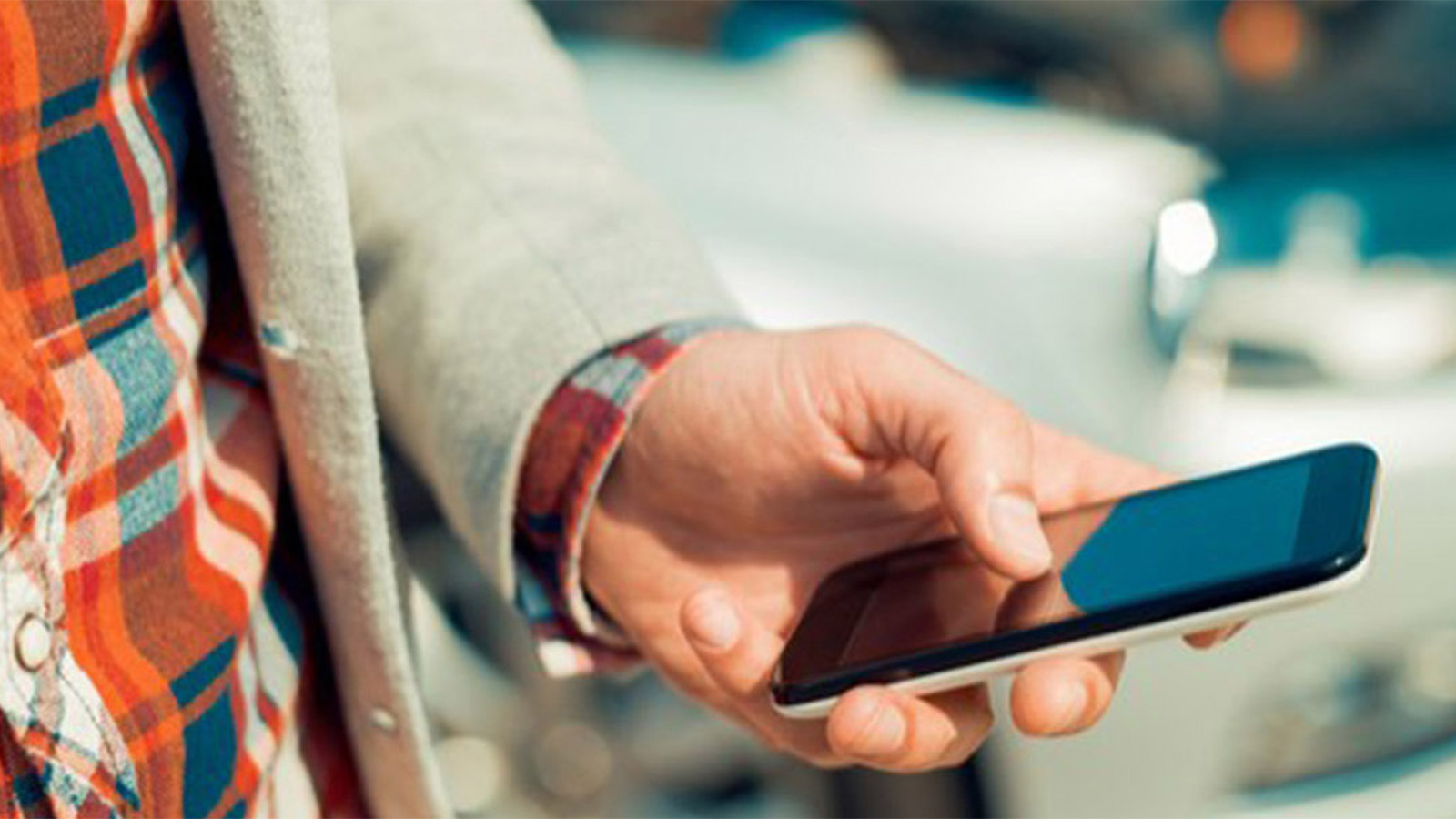 Close-up of a hand scrolling an iPhone.