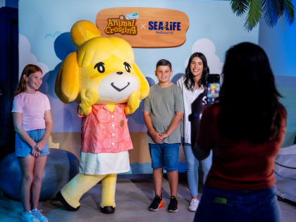 Kids taking a photo with an Animal Crossing character at Sea Life Aquarium Melbourne.