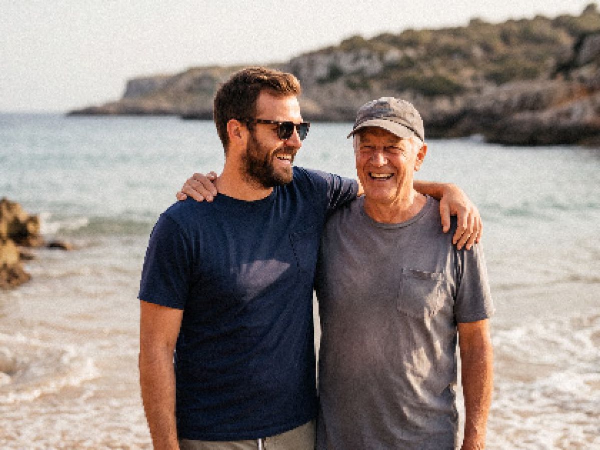Father and son on the beach arm in arm.