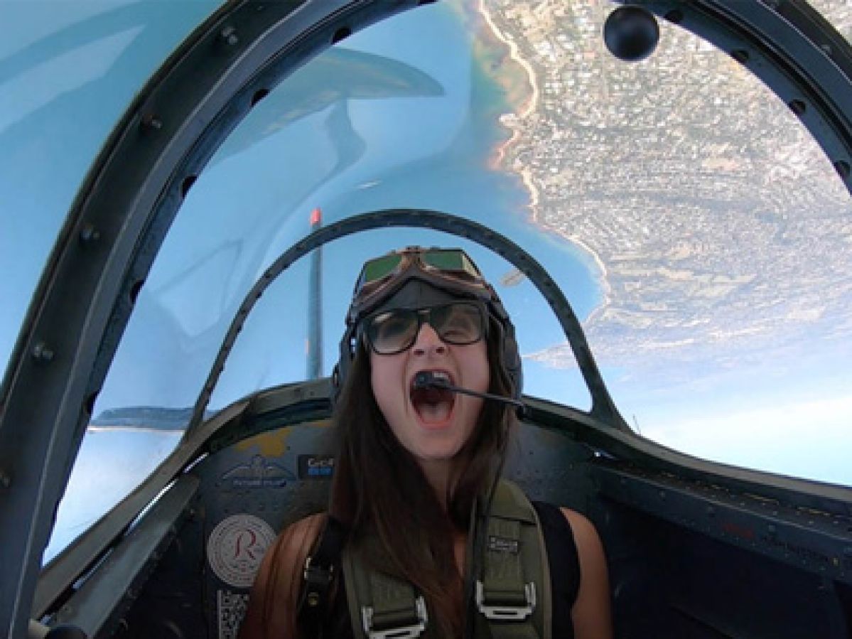 A woman in a jet cockpit screaming with excitement. 