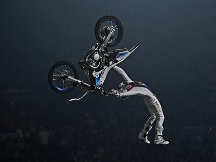 A person doing a backflip in the air on a motorbike