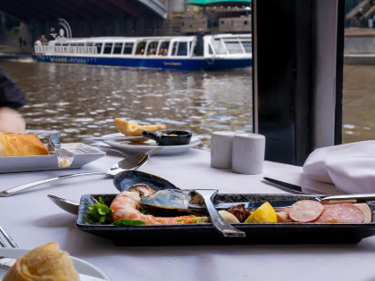 A plate of lunch with views of a river cruising boat