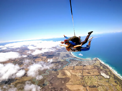 Two people skydiving over the coast