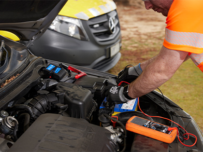 RACV employee fixing a car battery. 