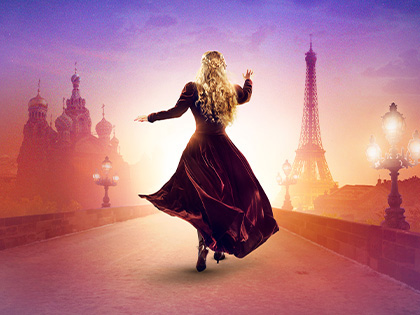 A woman wearing a dress dancing on a road with buildings in the background. 