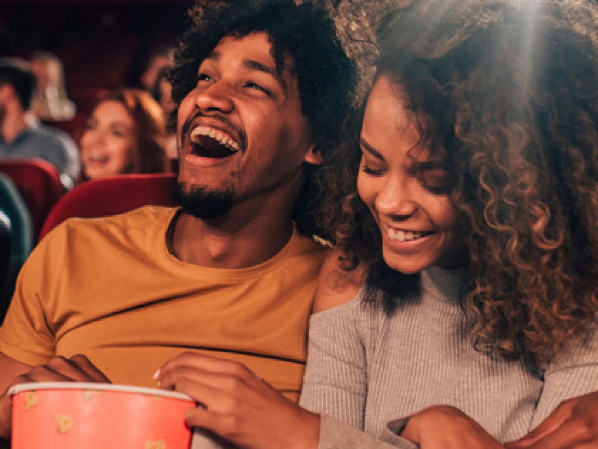 Couple laughing together at the movies.