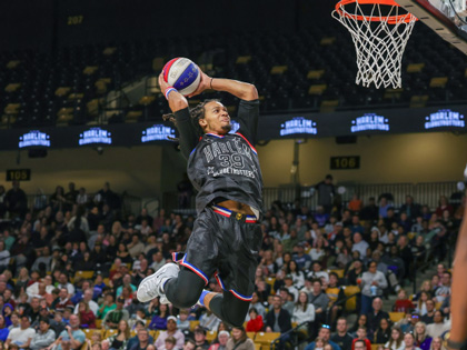 A basketball player in the air ready to slam dunk