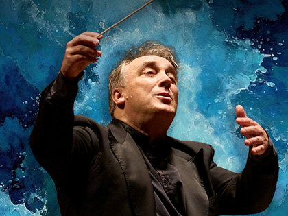 A conductor with a blue background that resembles water splashes