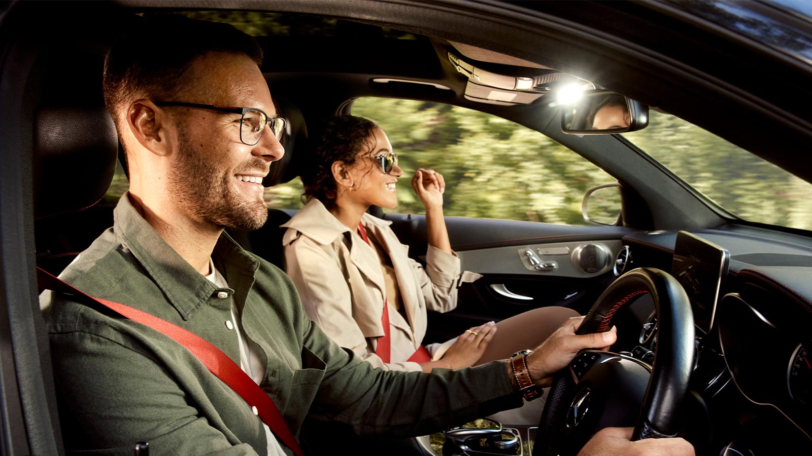 A couple smiling in their car while wearing OPSM glasses.