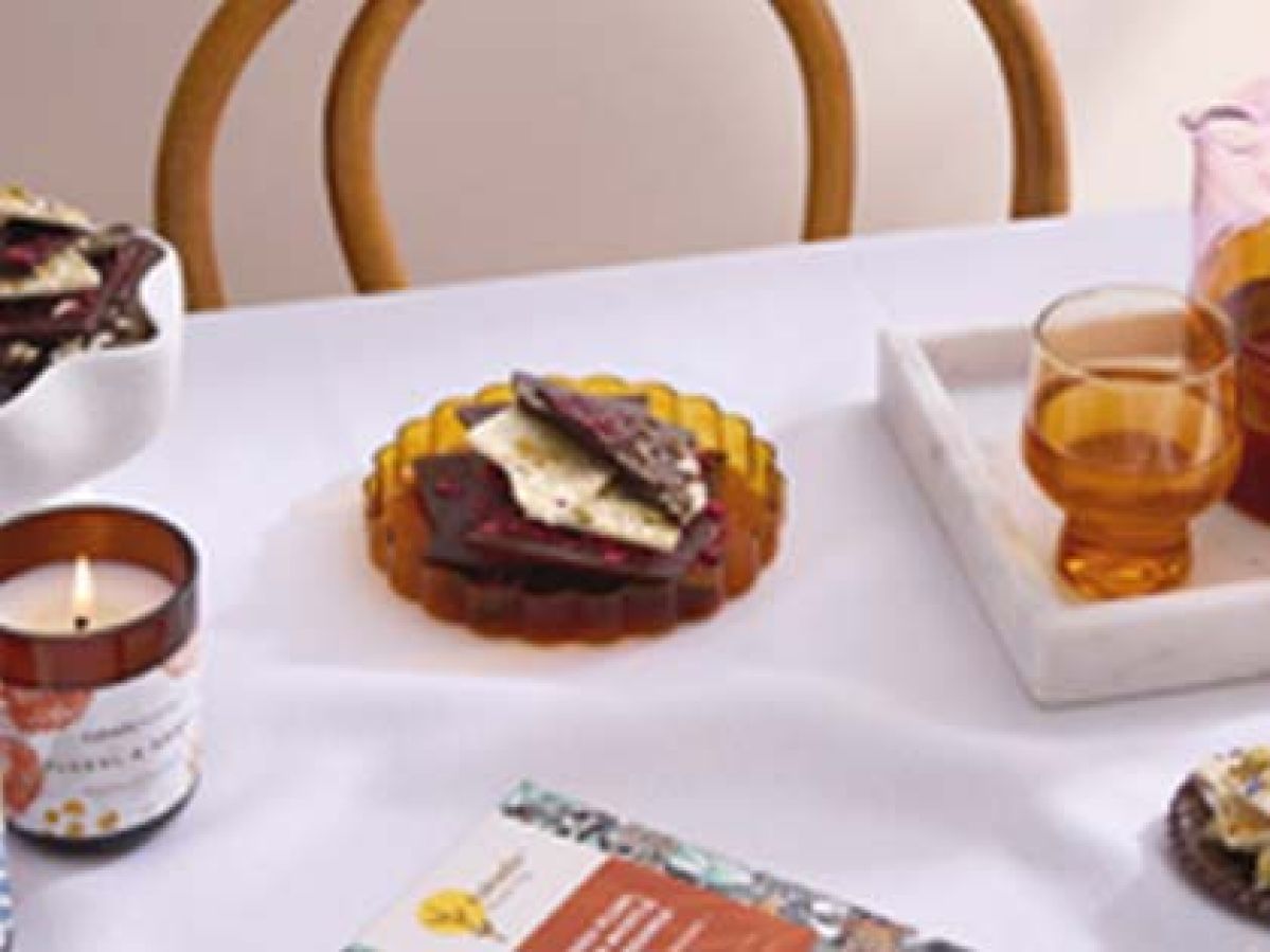 A table spread with tea, a candle, chocolate and more.