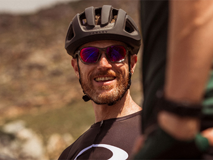 Bike rider smiling and wearing sunglasses with red tint frames.