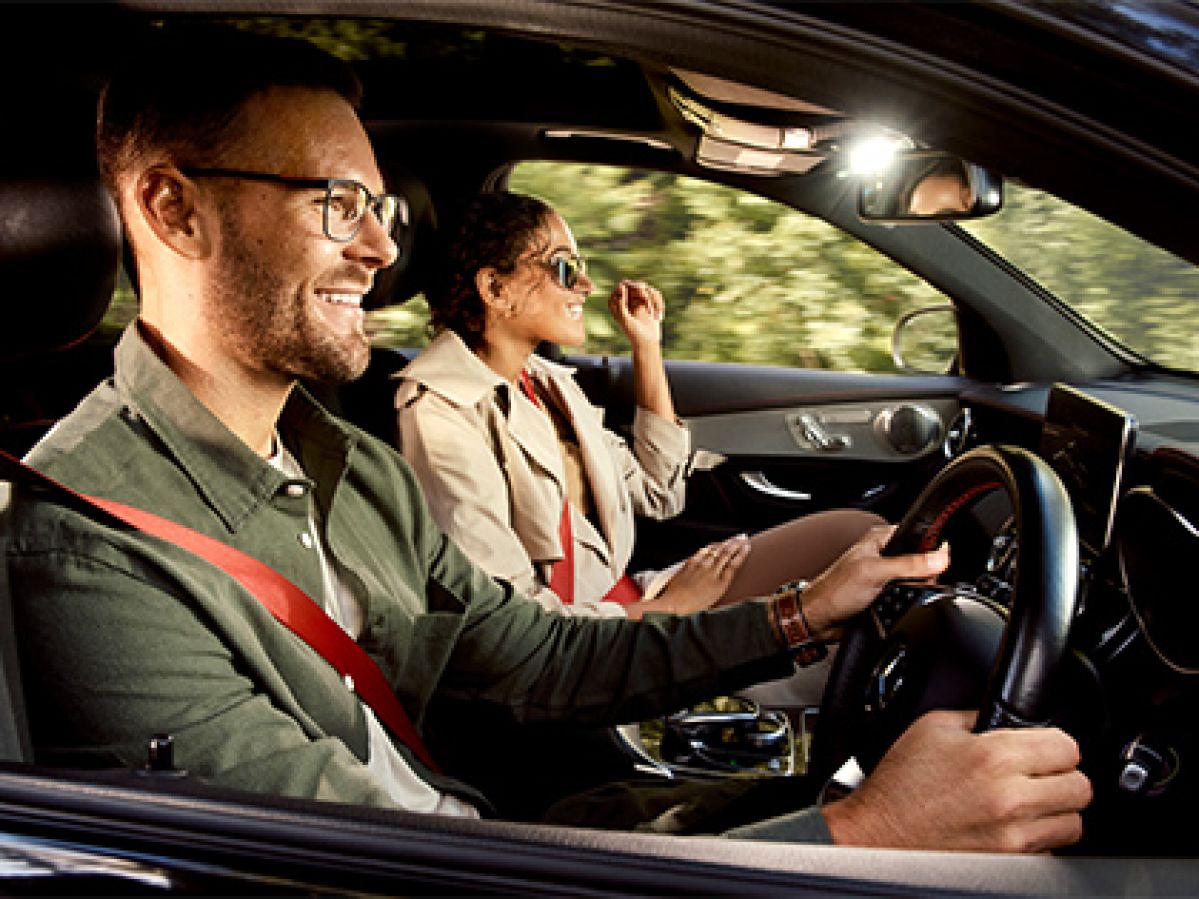 A couple smiling in their car while wearing OPSM glasses.