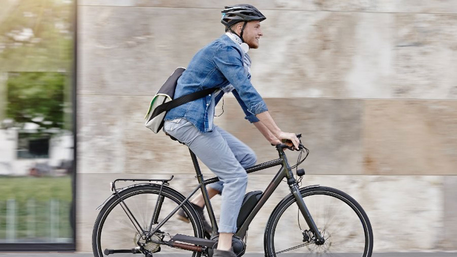 Smiling man riding a bicycle.