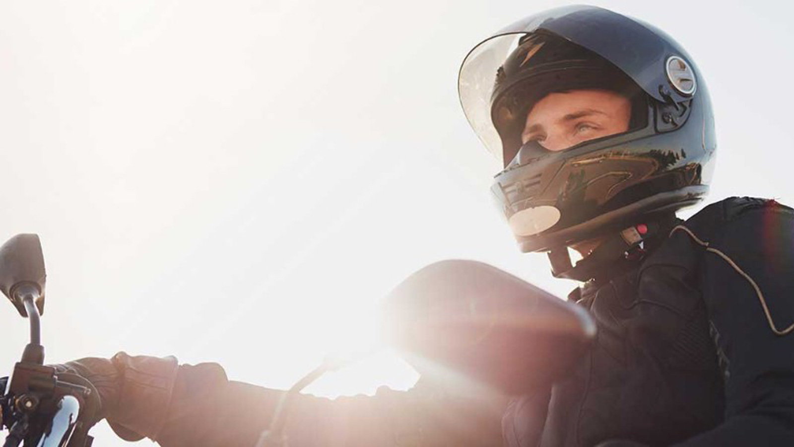Motorbike rider wearing a helmet and bike jacket.