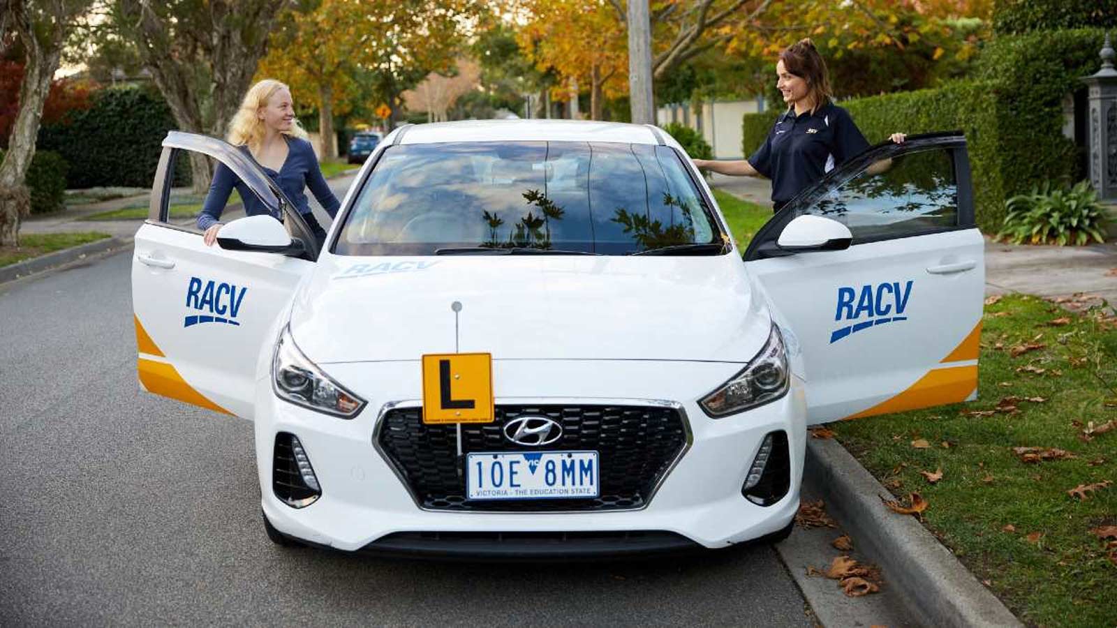 Driver and instructor getting into the front seats of a practice vehicle.