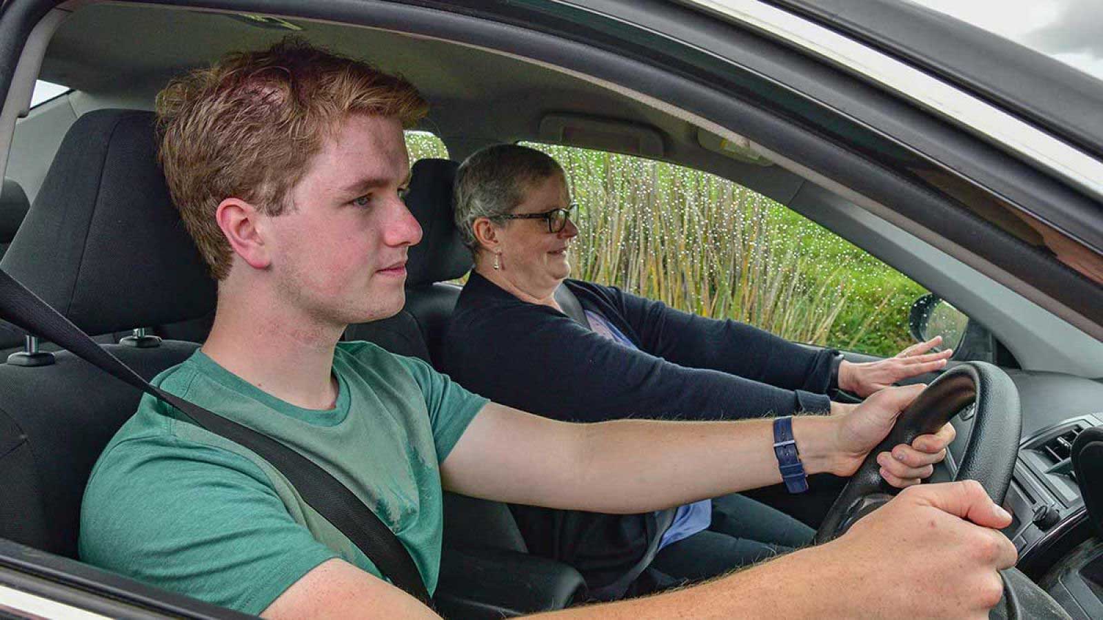 Young man in the drivers seat with an instructor as the passenger.