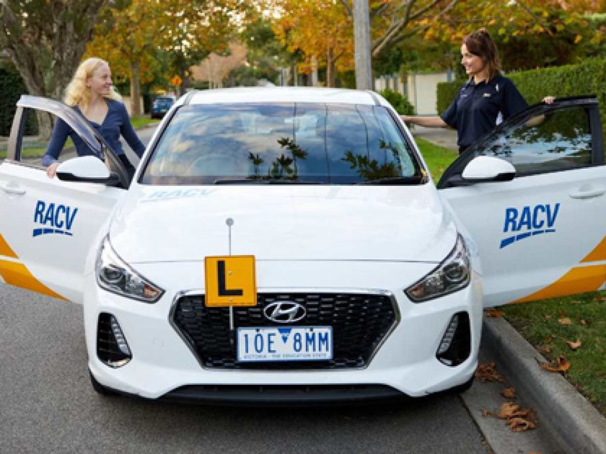 Driver and instructor getting into the front seats of a practice vehicle.