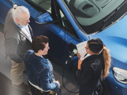 An aerial view of people standing next to a blue vehicle.