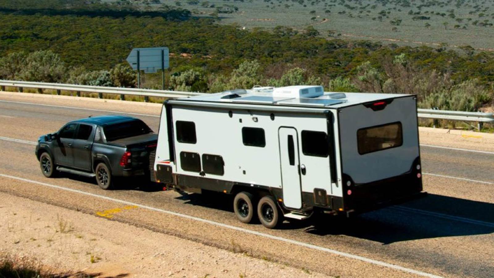 Ute towing a caravan on an outback road.