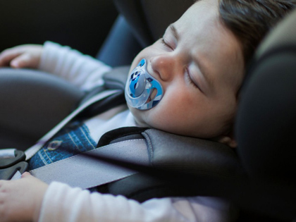 A sleeping baby in a car seat.