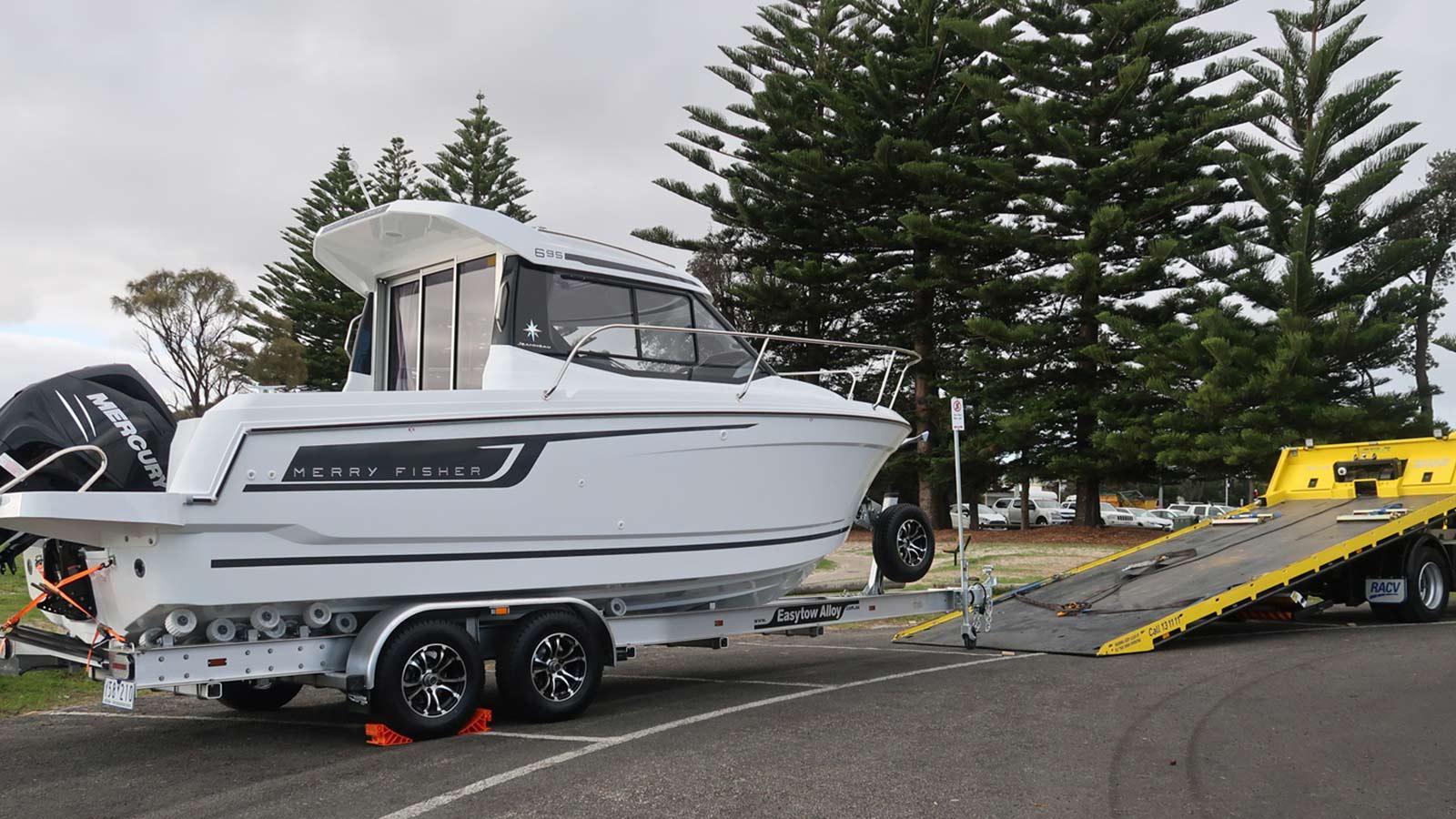 A boat trailer next to an RACV Emergency Roadside Assistance van.