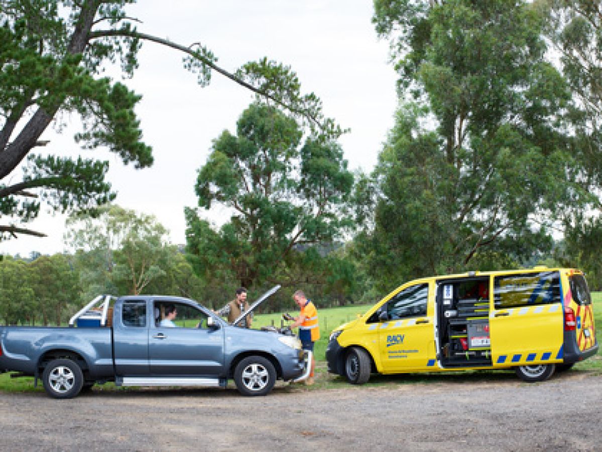 RACV patrolman in a rural area testing a customers battery on the roadside.