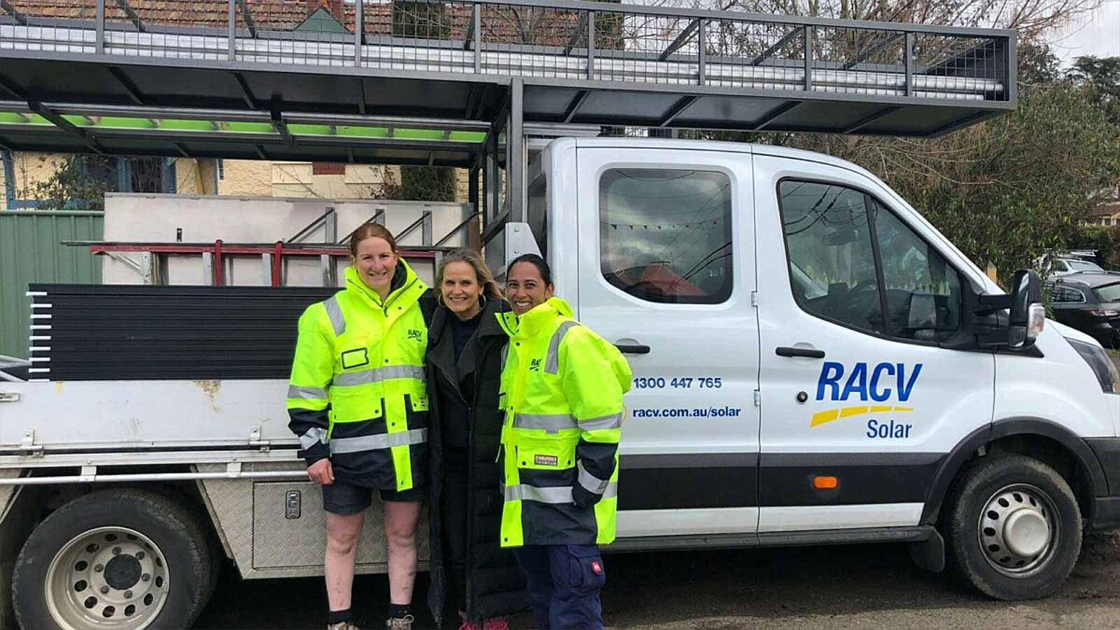 Mel, Tracey and Shaynna on set of Country Home Rescue, standing in front of a RACV Solar truck filled with solar panelling. 
