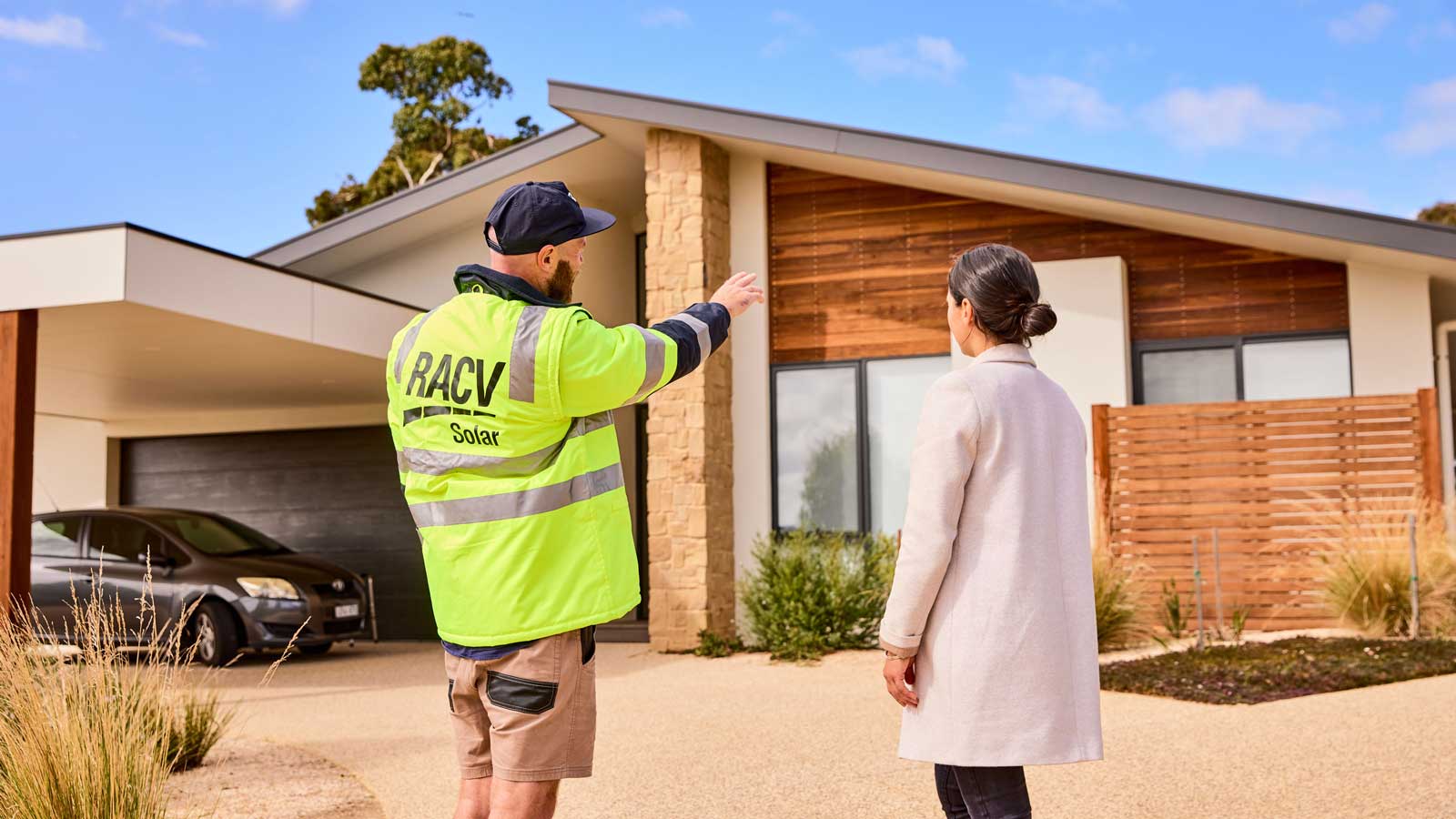RACV solar installer and RACV customer talking in front of a house. 