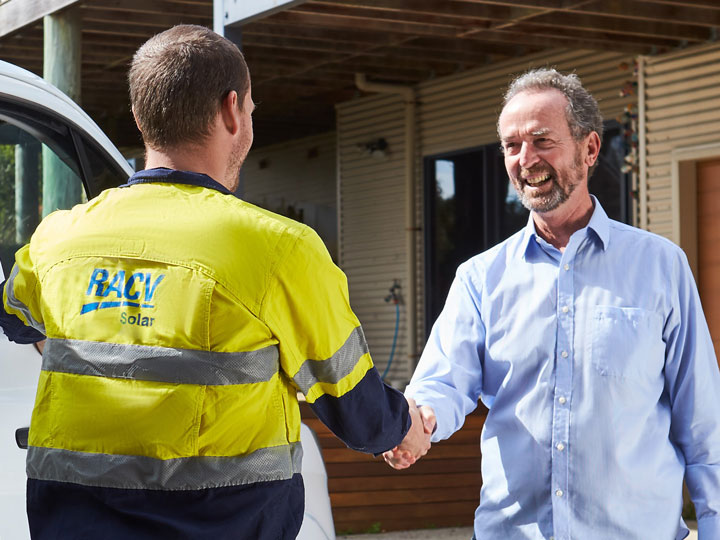 RACV solar installer greeting and shaking hands with a smiling customer.