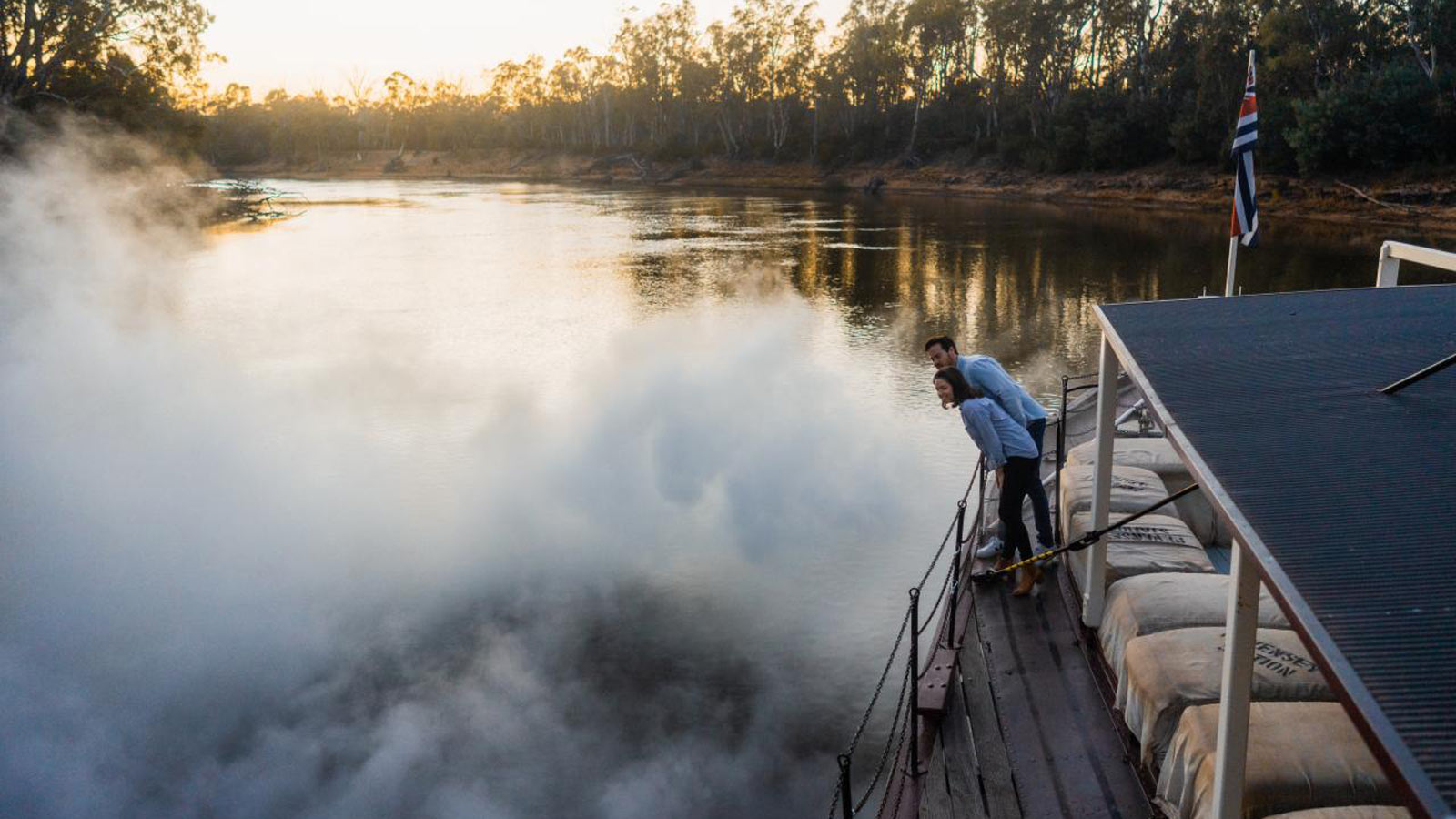 Couple on a steam boat together looking over the edge