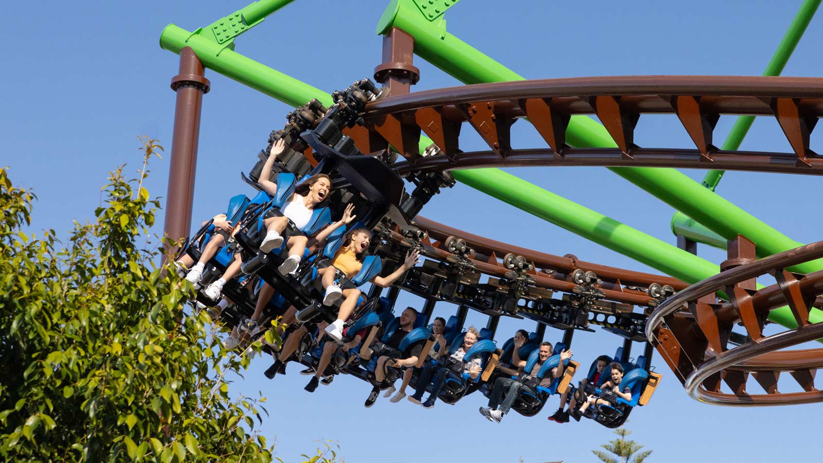 People cheering as they ride on a roller coaster