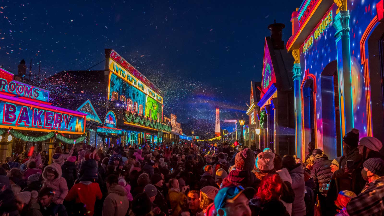 The night lights shining at Sovereign Hill with large crowds gathered to enjoy them. 