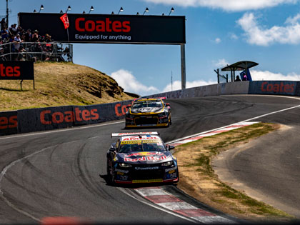 Two cars racing on a track in Bathurst. 