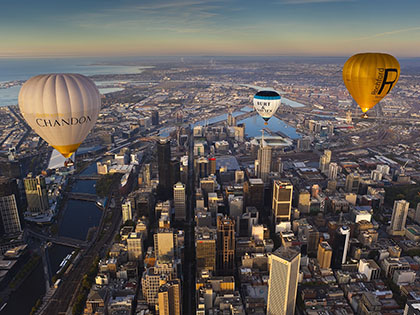 Hot air balloons over city.