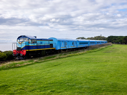 The Q Train in Geelong next to the water and grass.