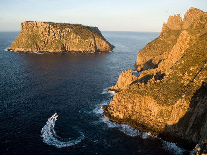 A boat in the water at Tasman Island and Cape Pillar