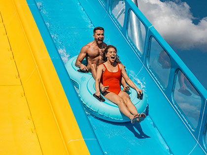 Man and woman riding on floating rings down water slide at Wet'n'Wild.