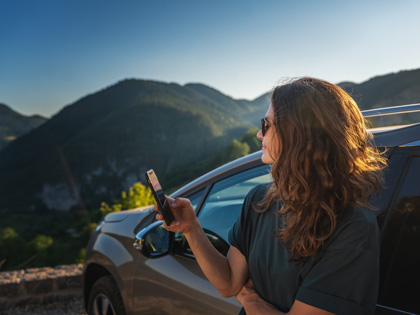 Woman leaning against a car