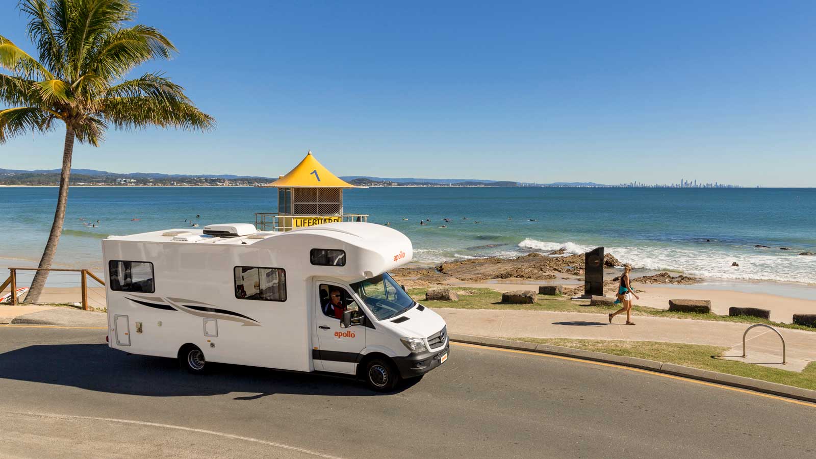 An Apollo campervan parked beachside on a sunny day.