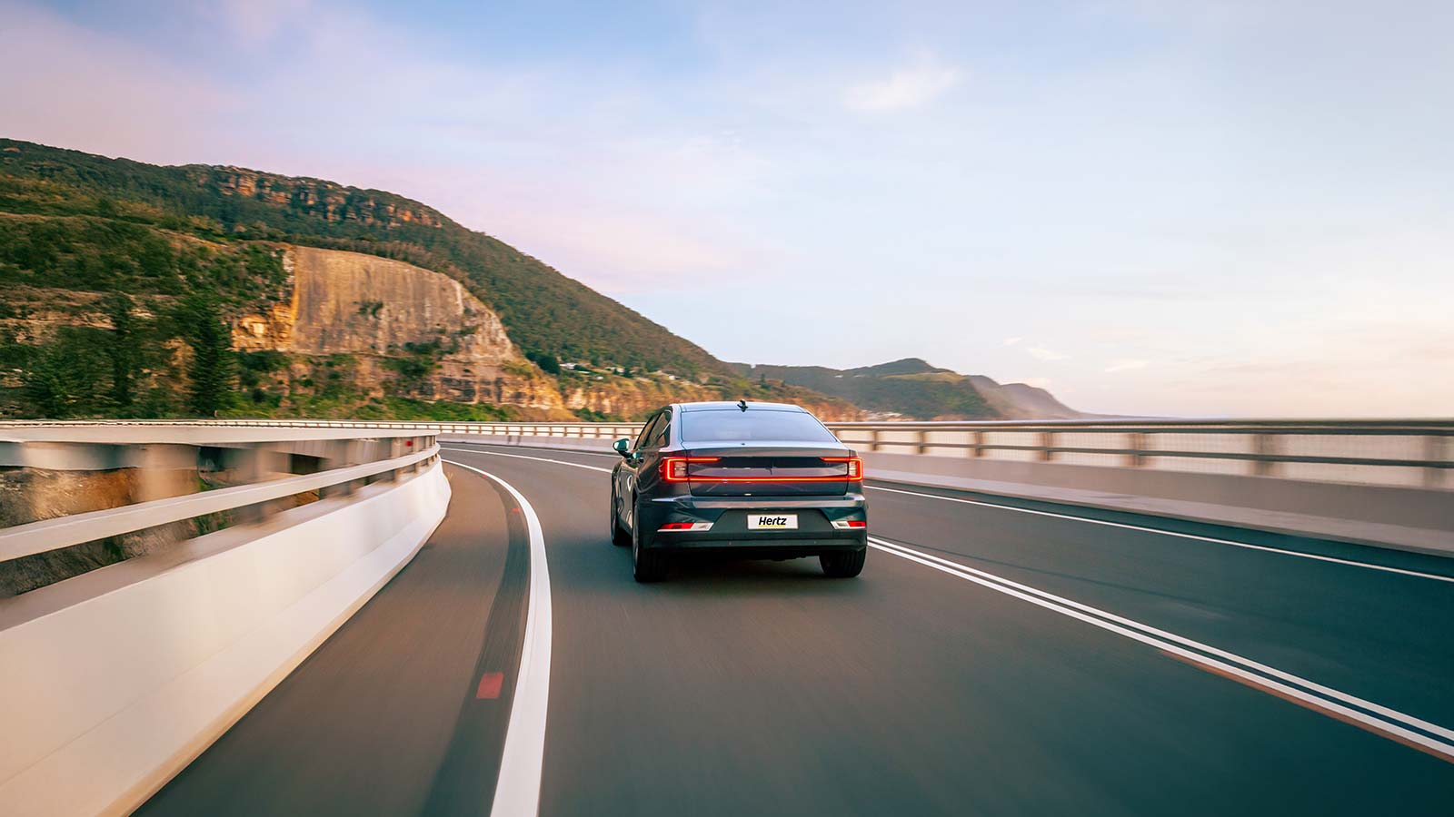 Hertz hire car driving along a coastal highway.