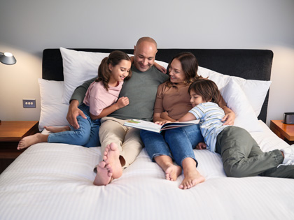 Young family enjoying a cuddle on the King sized bed.
