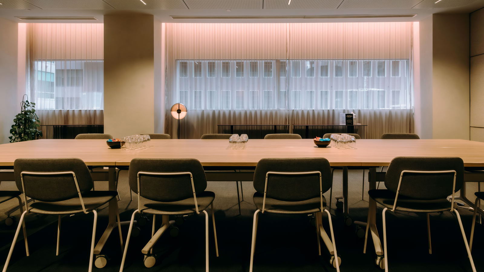 A table set in a meeting room with eight chairs.