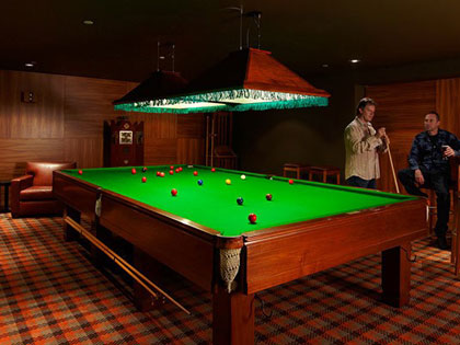 Two men playing billiards at RACV City Club.