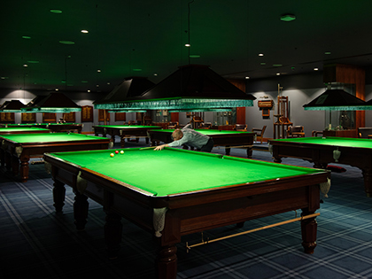 Person lining up a shot in the billiards room at RACV City Club.
