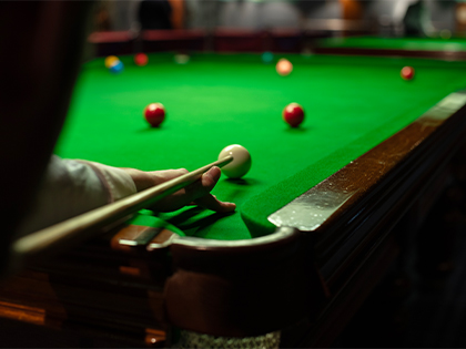 Member lining up their shot on a pool table.