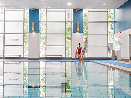 Woman stepping into the city club pool.