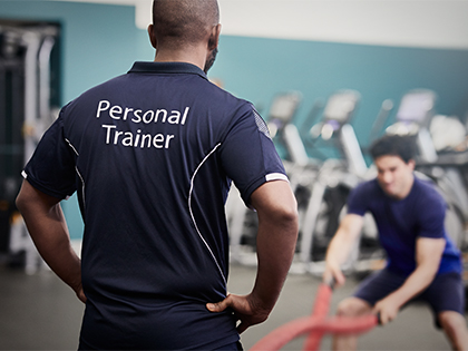 Personal trainer coaching a client in the gym.
